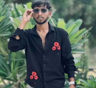 A man in a black shirt is holding sunglasses in his hand